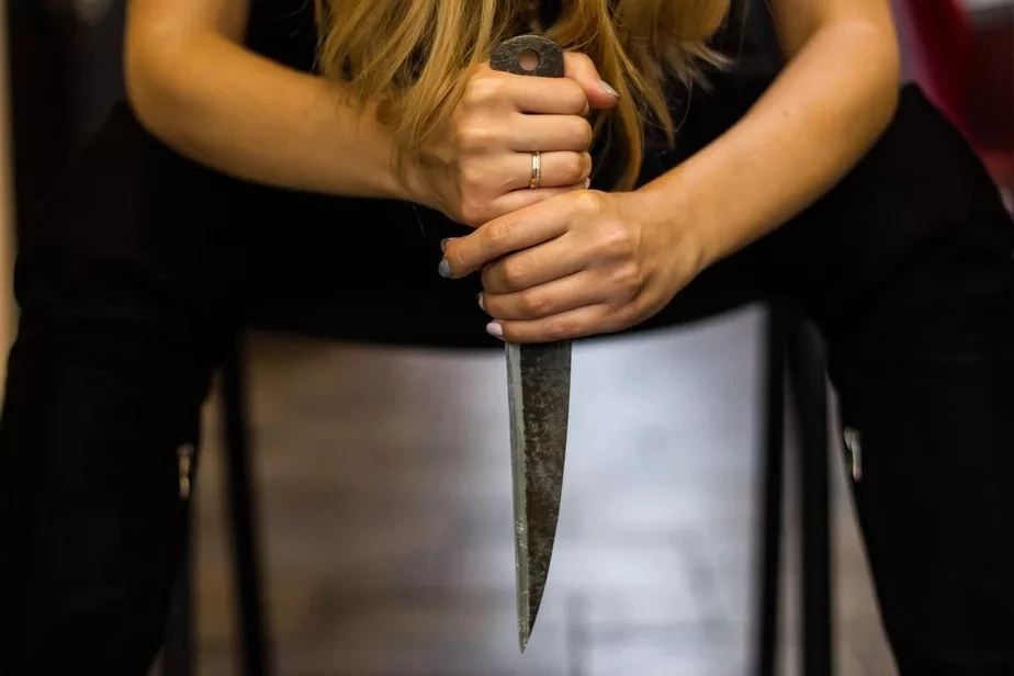 Женщина держит нож