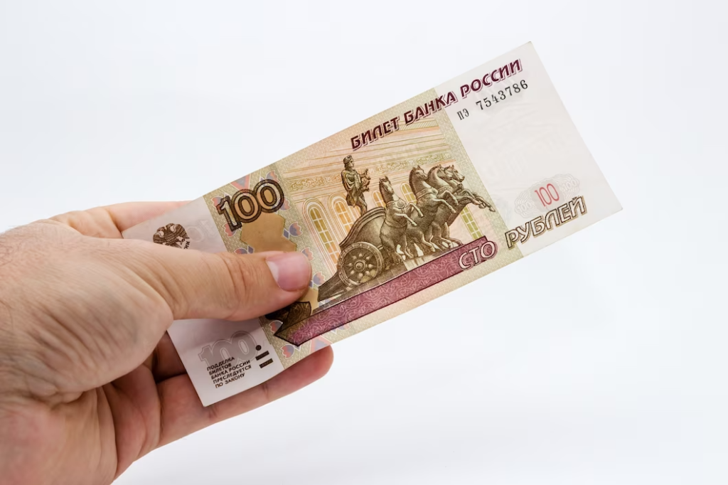 Россияннка держит в руках бумажные сто рублей