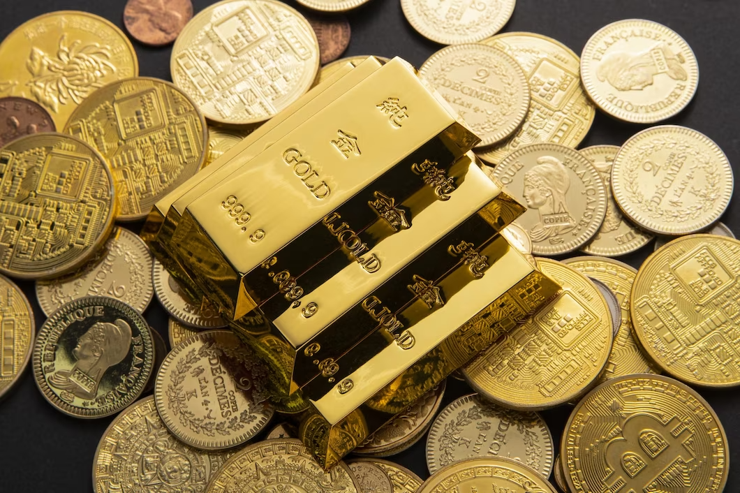 Золотые слитки и монеты лежат на столе в банке